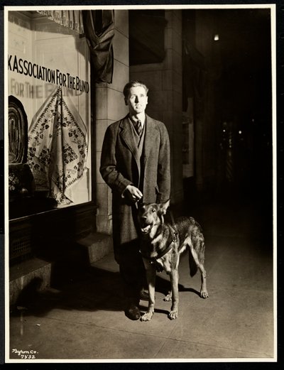 Blind Man and His Guide Dog on the Sidewalk in Front of the New York Association for the Blind, 111 East 59th Street, New York by Byron Company